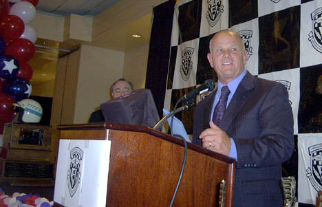 Gary Densham accepts the Jerry Titus Memorial Trophy on behalf of John Force. Photo by RIS