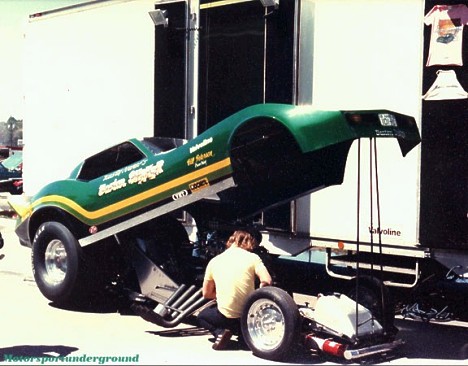 Kosty Ivanof's Corvette undergoes between rounds maintenance at NED, requisite souvenir Ts and halter tops in the background. Photo by James Morgan