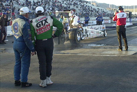 Gary Densham and John Force watch Ashley Force do a burn-out.
