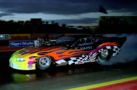 Patrick Wikstrom laying rubber at dusk with his stunning blown Pro Mod Camaro. Photo by Sharkman