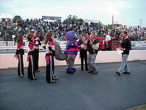 Royce Miller greets Lugnut, the Racing Squirrel, as announcer Lewis Bloom and the Second Dimension dancers look on. Photo by Tim Pratt